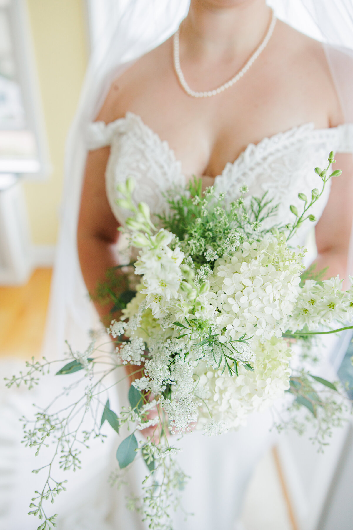 Closeup of a bride holding a white floral bouquet representing the timeless wedding details Christine Hazel Photography documents