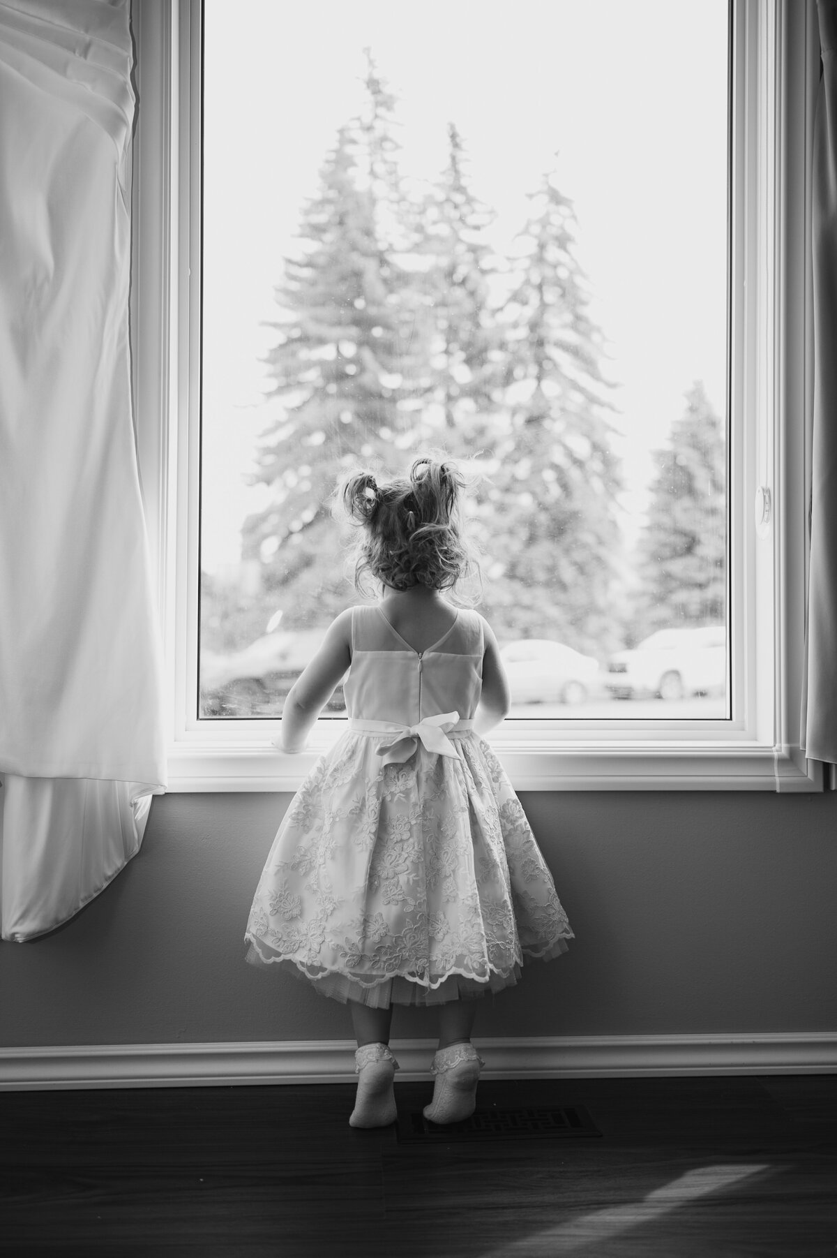 flower girl looking out window at edmonton wedding venue