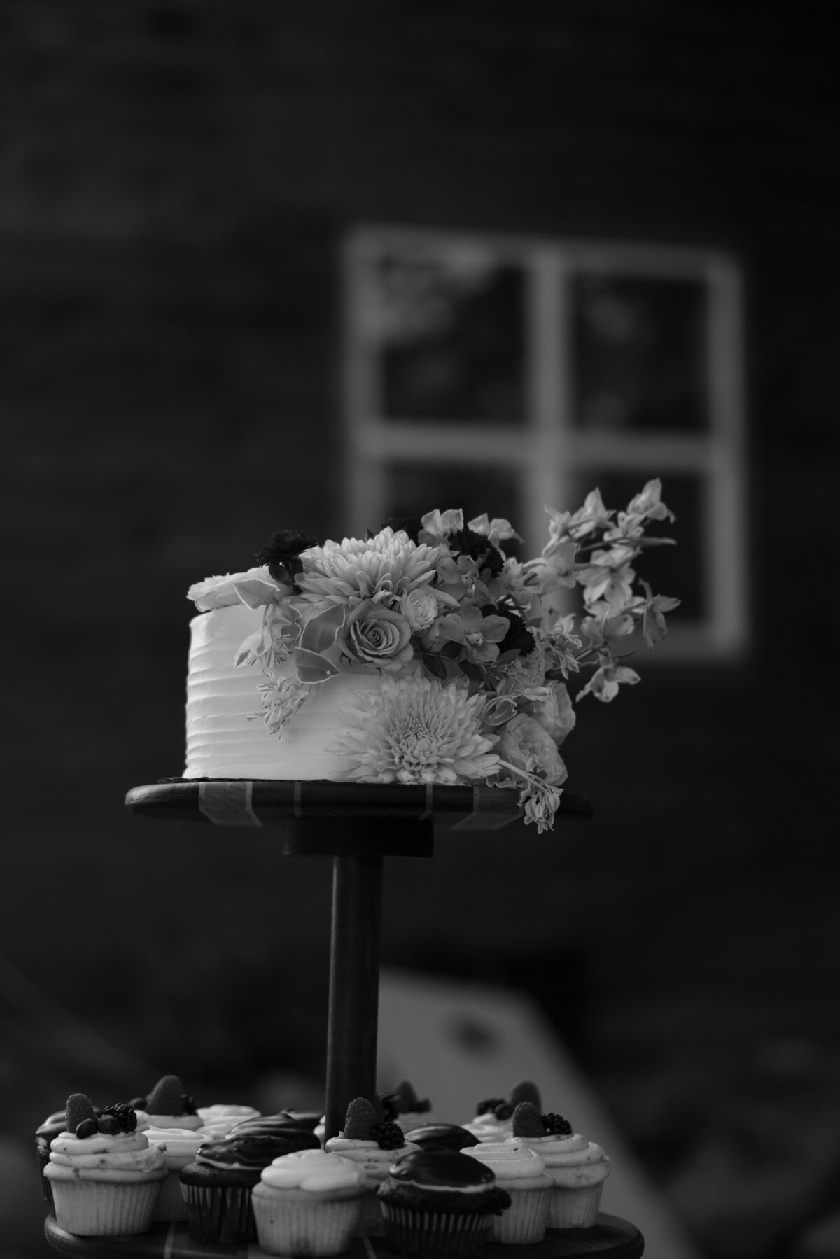 An elegant, hand-decorated wedding cake, featuring soft florals and timeless details, captured at a high-end McCall, Idaho wedding.