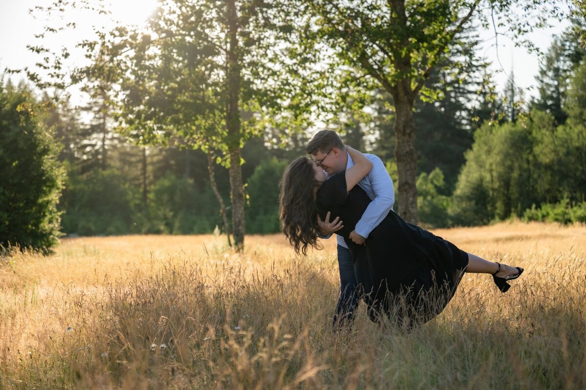 man dips girl engagement portraits open field dress