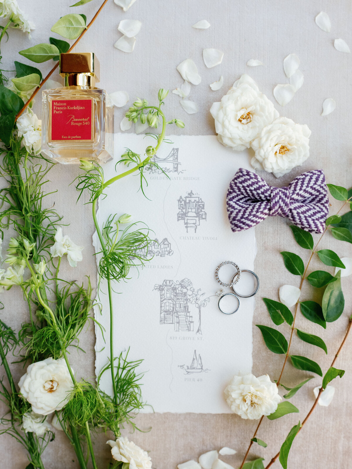 loose leaves and flowers tossed with a custom  wedding stationery and bride's personal details at an exclusive destination wedding in san francisco