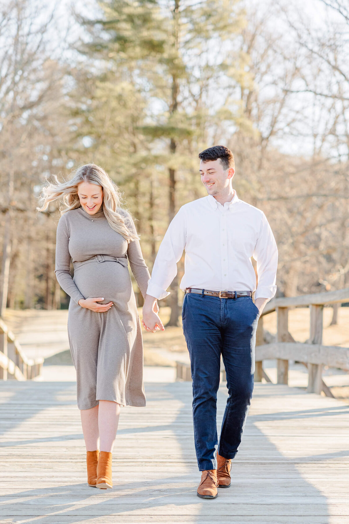 Pregnant woman and her husband walk across a bridge