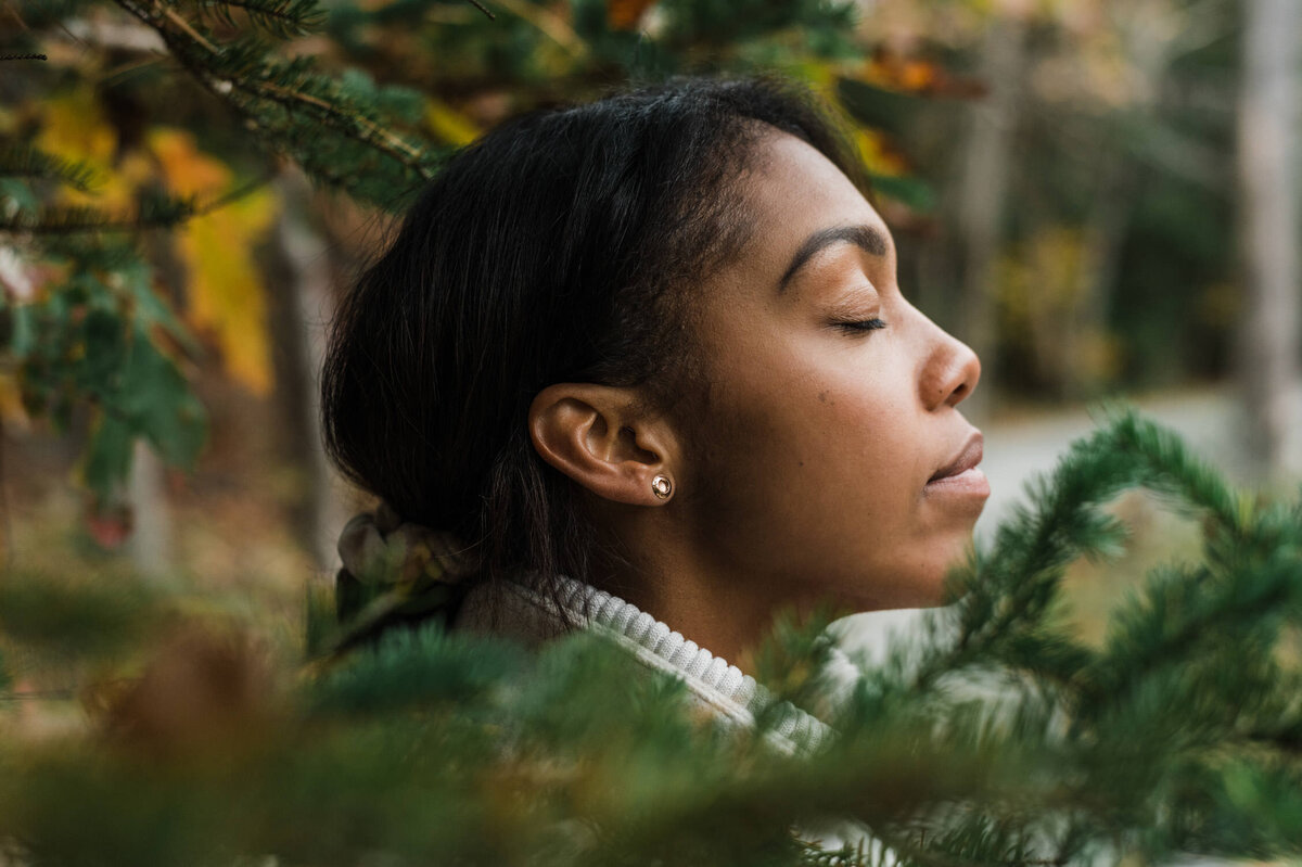 Peaceful woman with eyes closed in the forest.