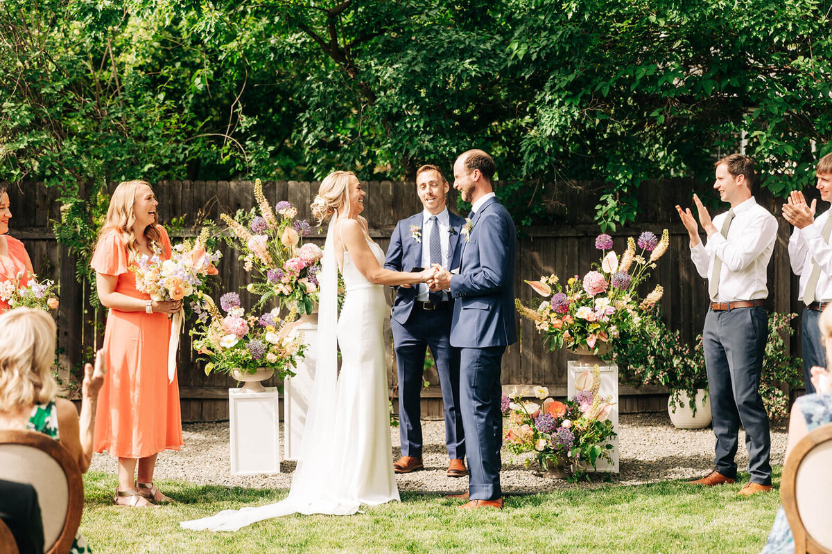 A bride and groom holding hands facing each other at an outdoor wedding ceremony planned by Perfect Thirds and Co. 