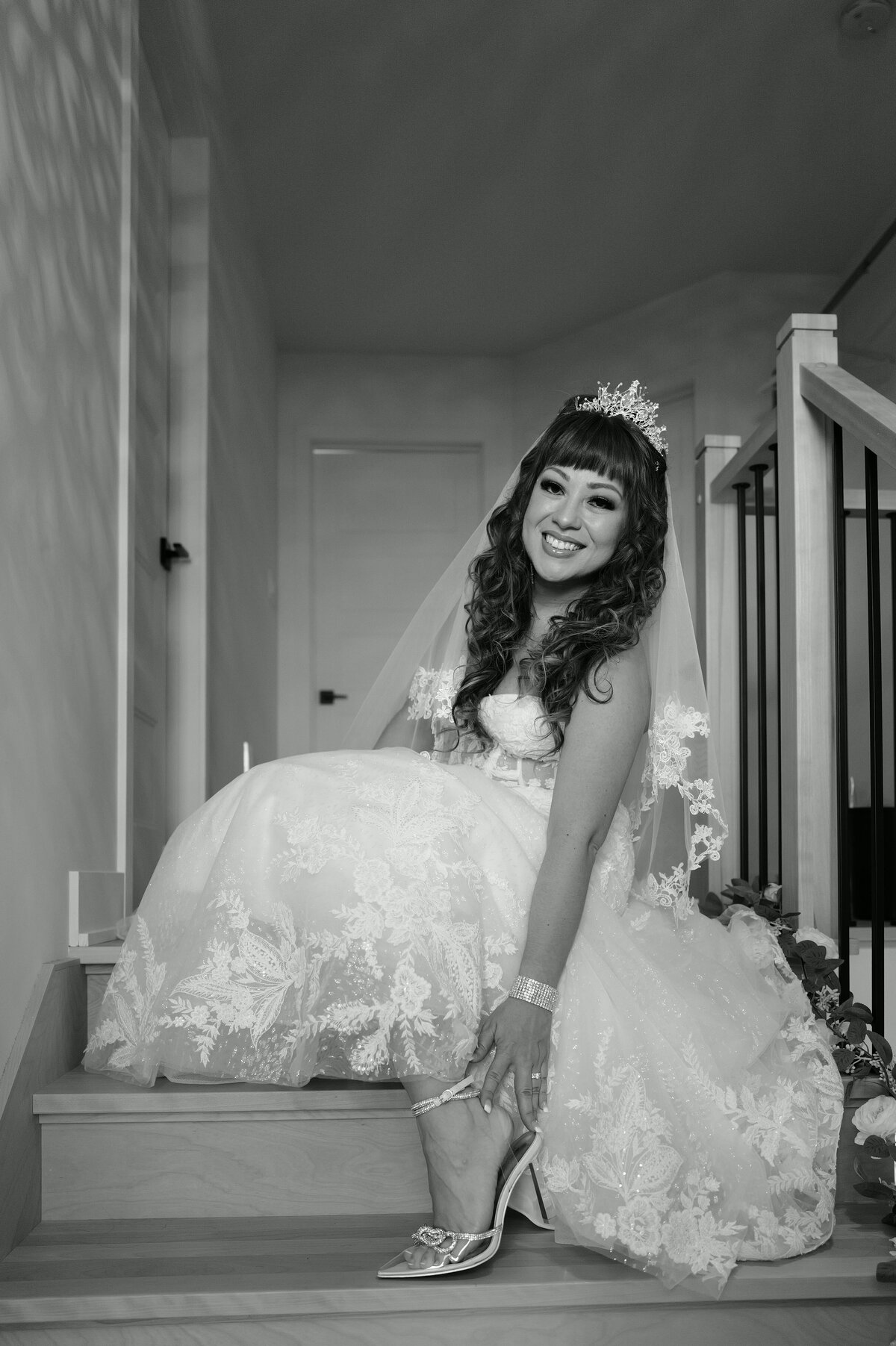 A bride puts on her shoes with delicate care, capturing a moment of anticipation and elegance. This image highlights the intricate details of her bridal attire and the graceful preparation process, reflecting the elegance and attention to detail of her special day.