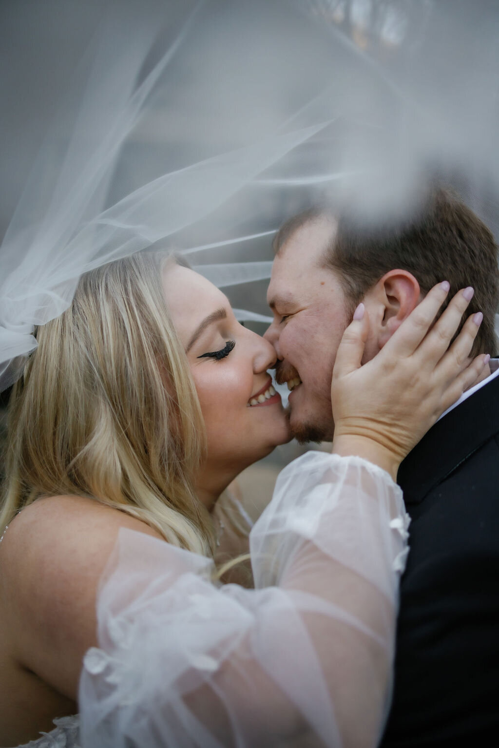 bride and groom embrace and kiss under the brides veil for romantic elopement photos captured by gatlinburg photographers