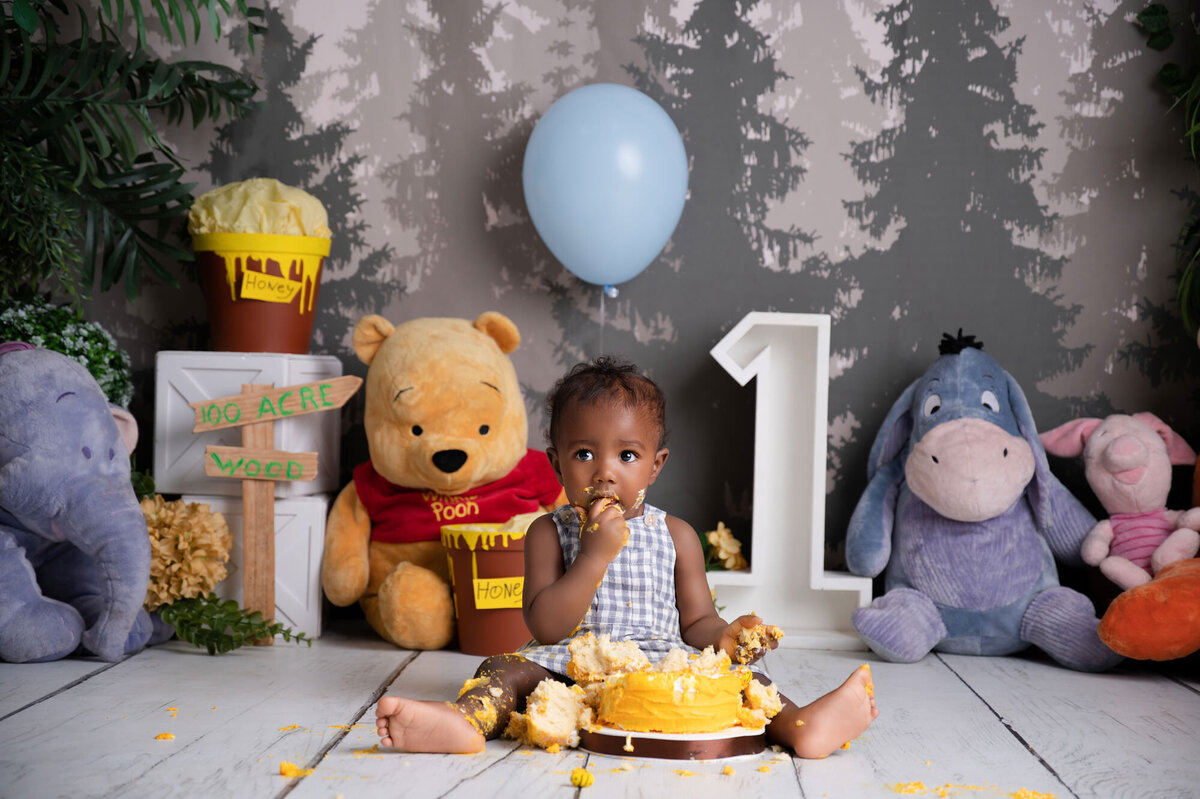 little one year old enjoying his first birthday cake