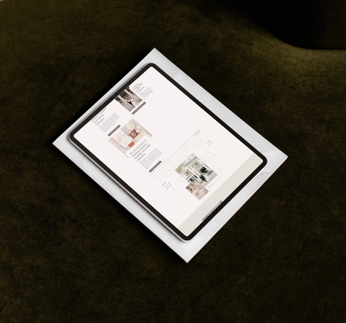 A tablet displaying a magazine page is placed on top of a closed laptop on a dark surface, showcasing ideas for a sophisticated wedding planner branding and website.