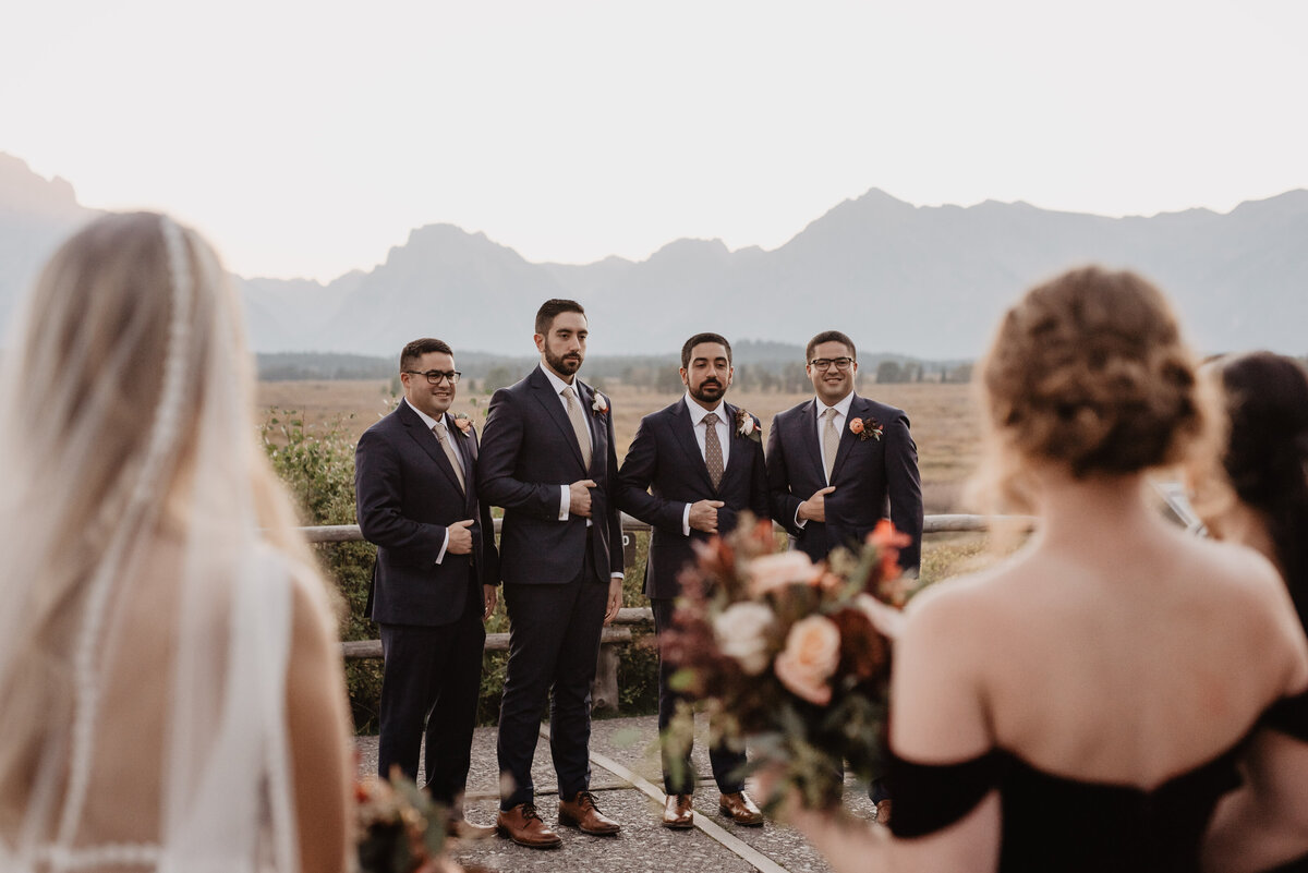 Photographers Jackson Hole capture bridesmaids and bride watching groomsmen
