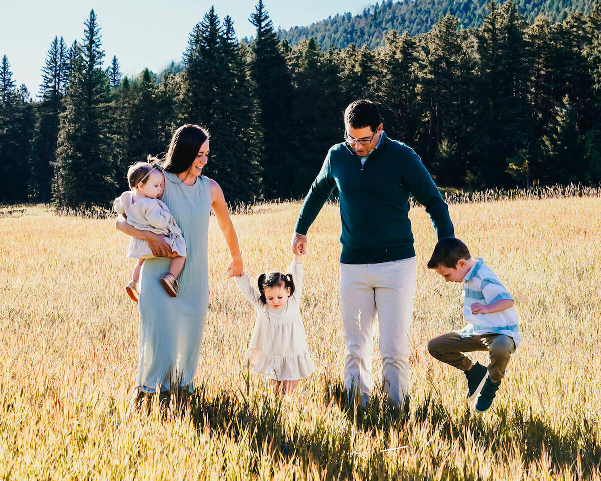 family photography denver co - parents holding children's hands in field