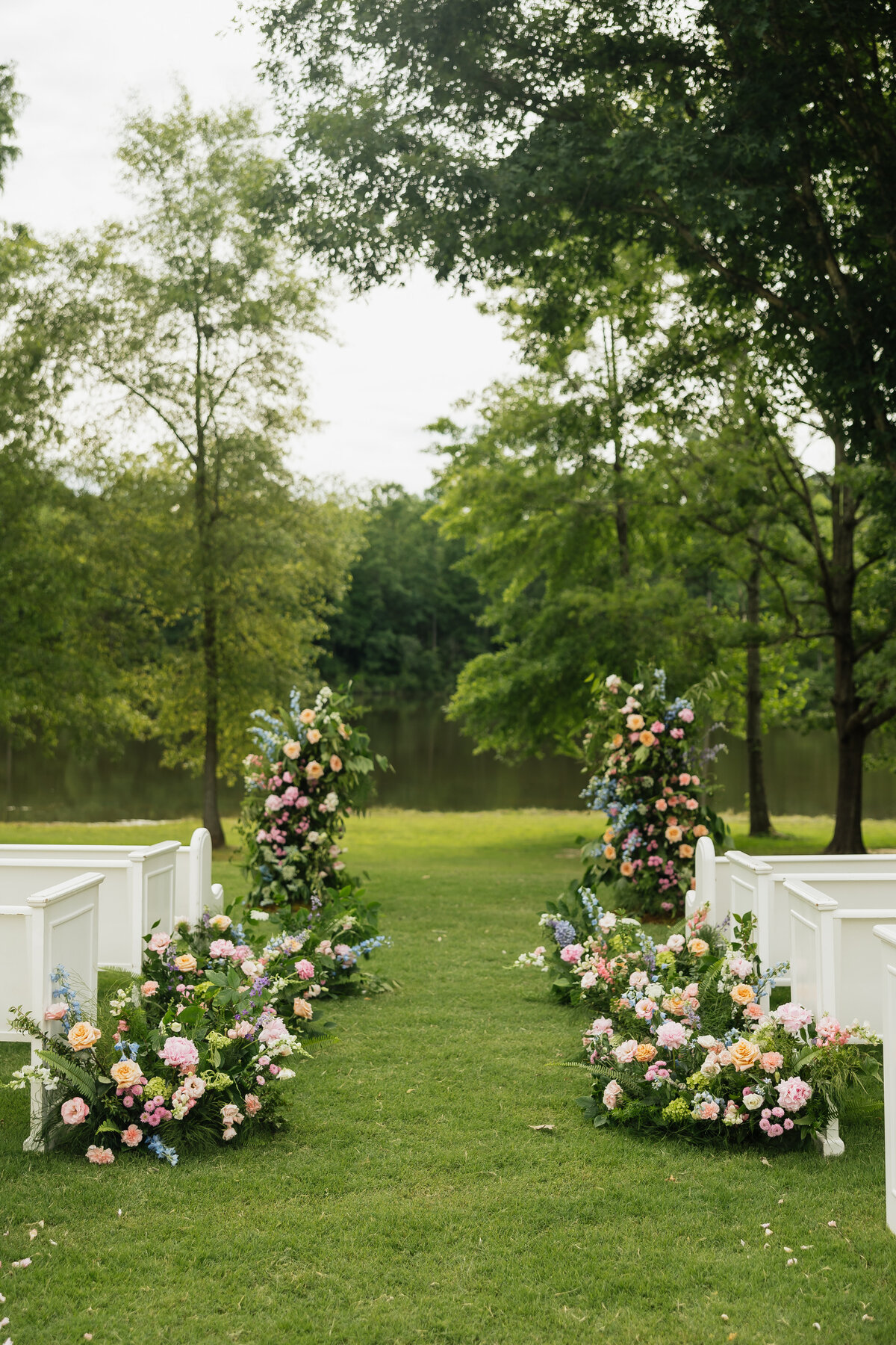 Colorful arbor and aisle arrangements designed by Abby Grace Florals at Dahlonega GA wedding