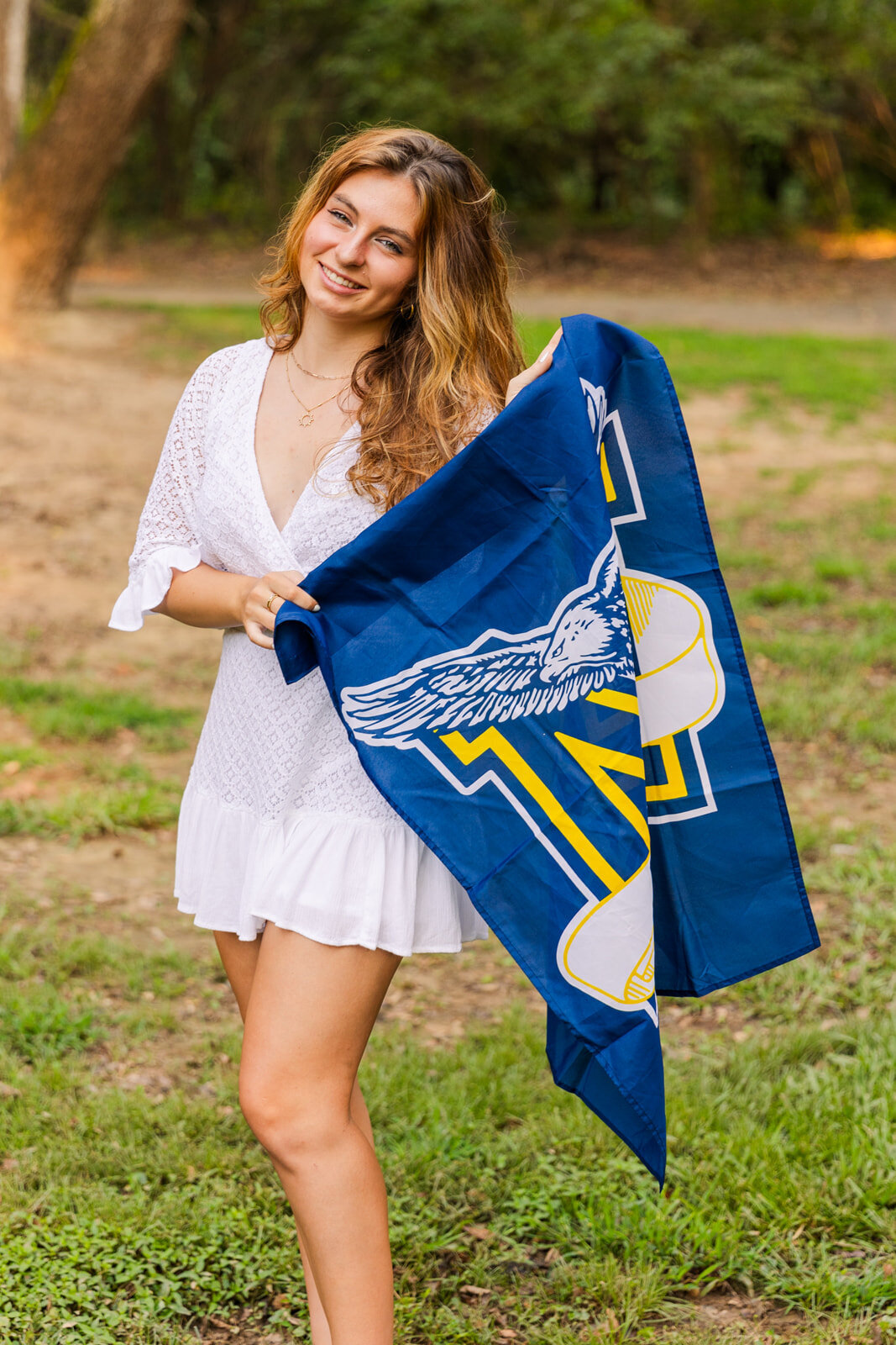 high school girl in a park  holding Marist school flag Atlanta Laure photography