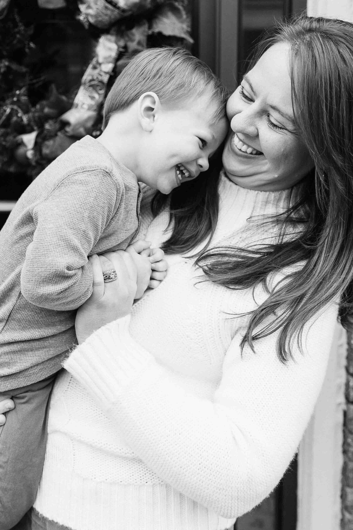 Mother holding son while they both laugh