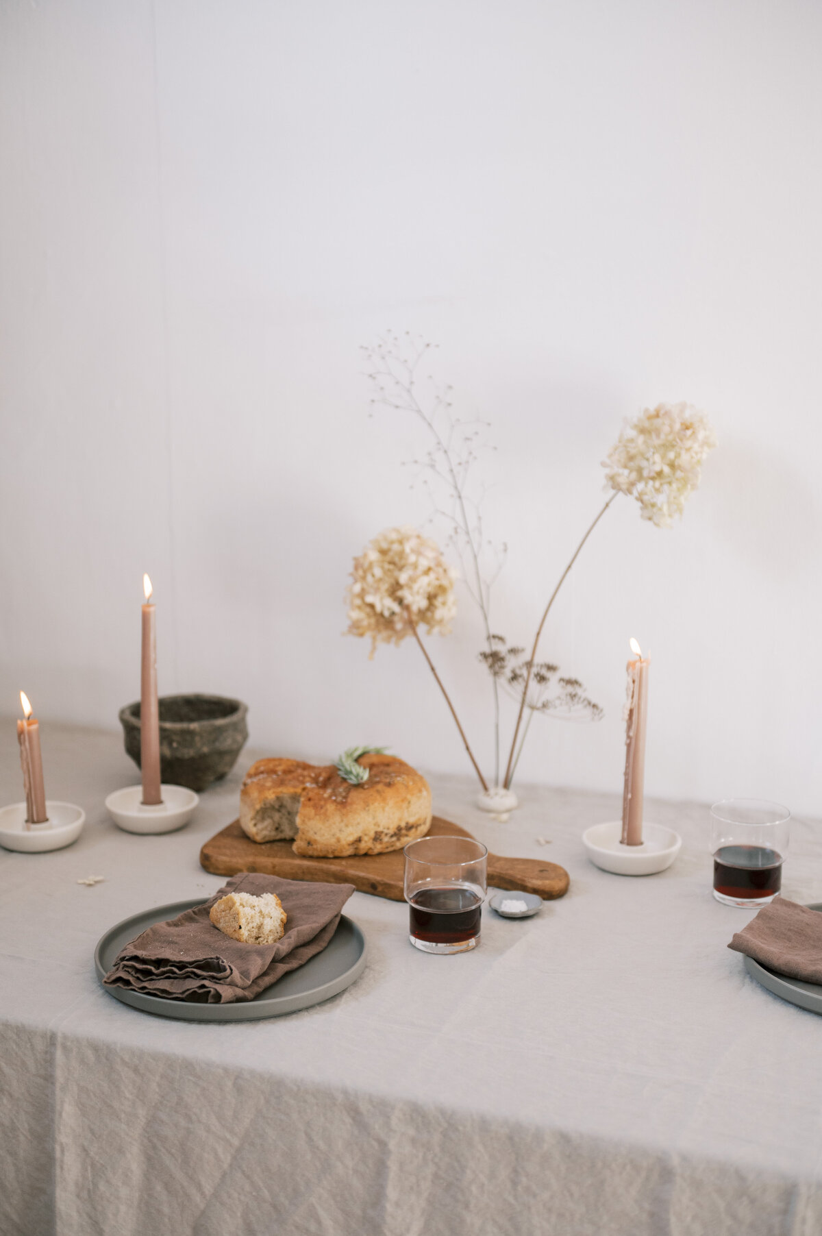 Upclose Grey minimalist Scandi tablescape with wine and bread on table 2