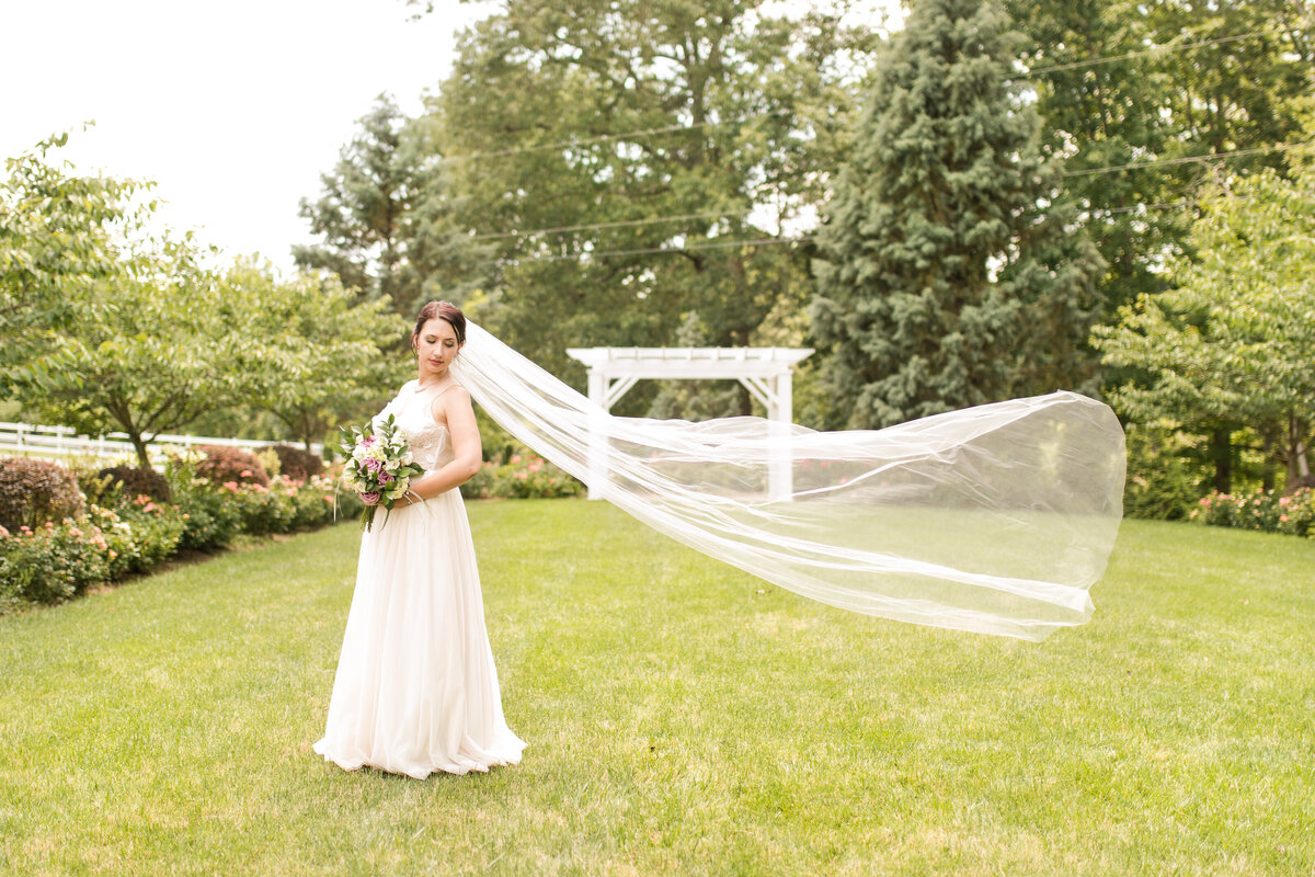 bride in a garden with flying veil