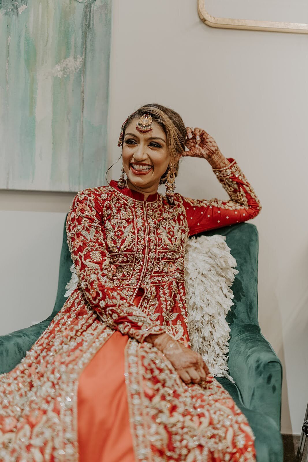 Bride poses in her red wedding after party outfit at the Bowery House and Gardens.