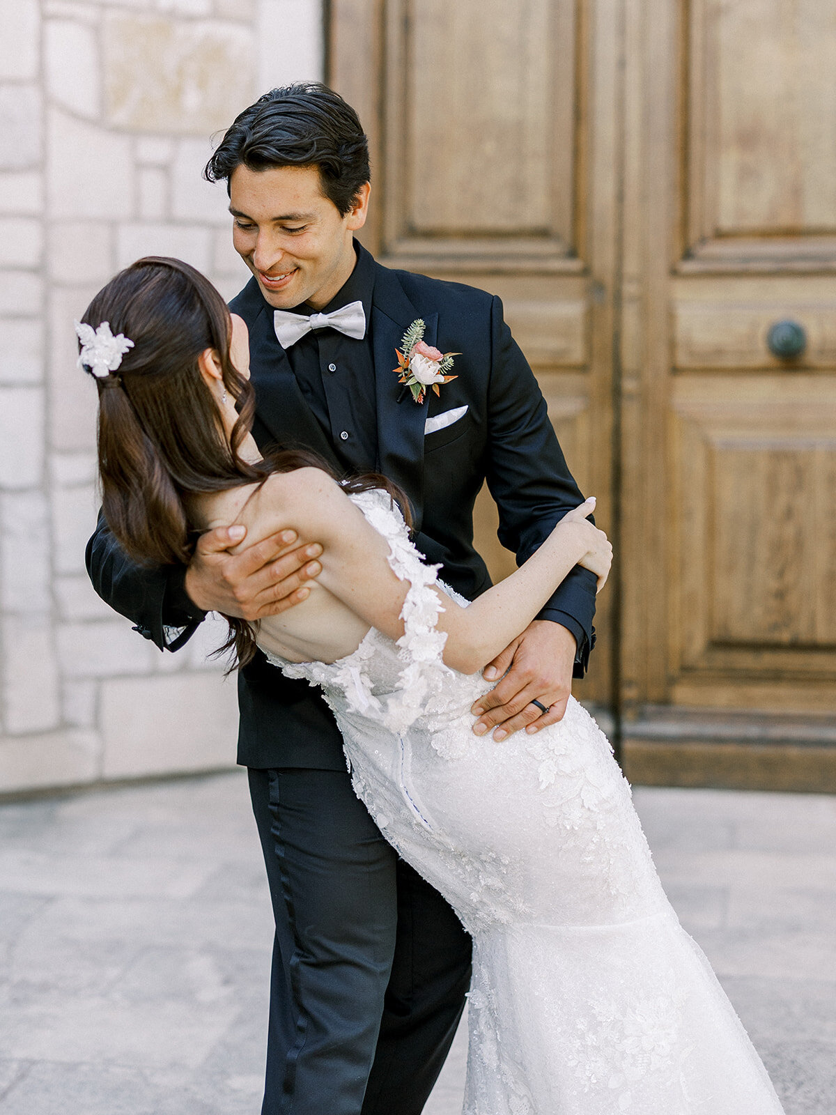 A bride and groom embrace during their first look in front of the chapel at allegretto Vineyards