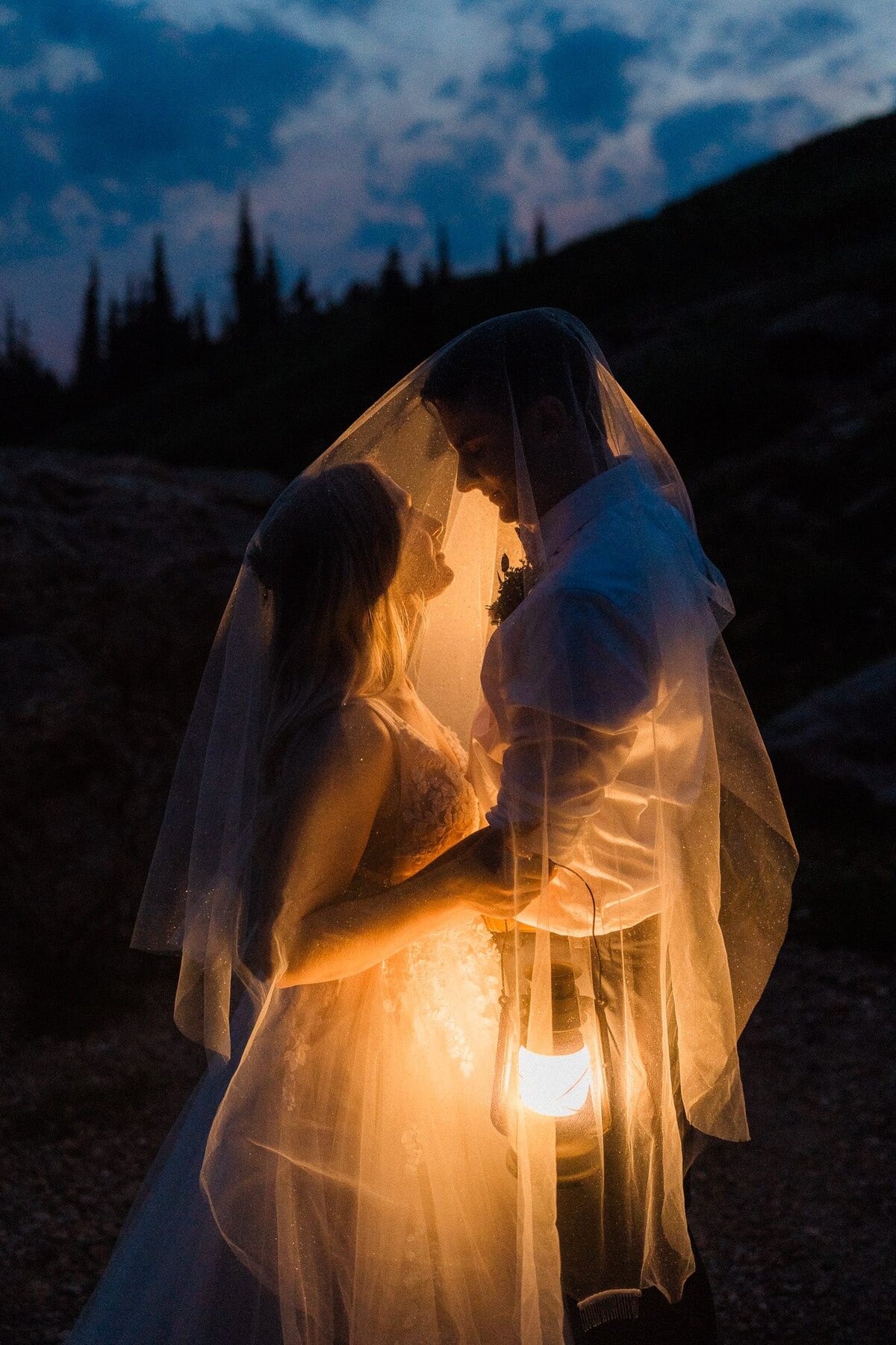 wedding couple under veil lit by lanterns at nighttime in washington
