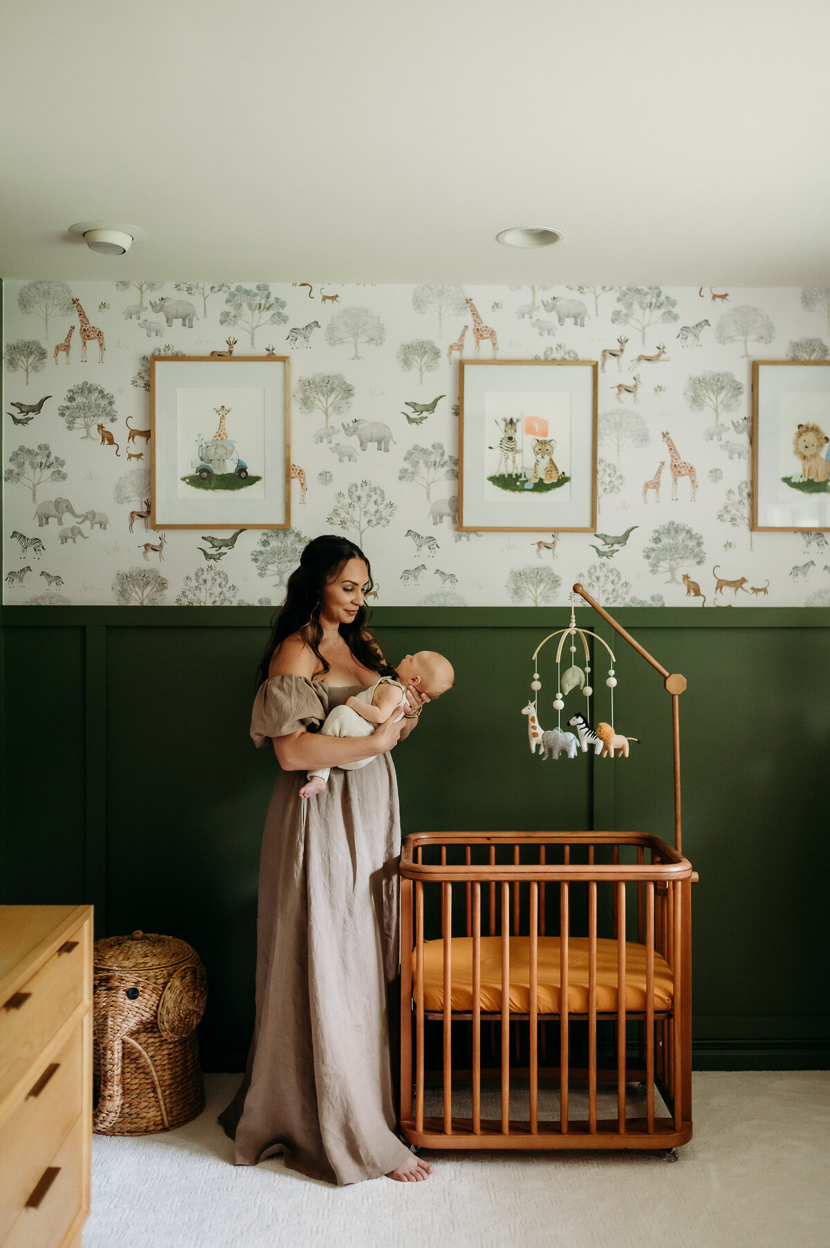 Mother holds child standing right over his crib during a lifestyle session in Timonium, Maryland