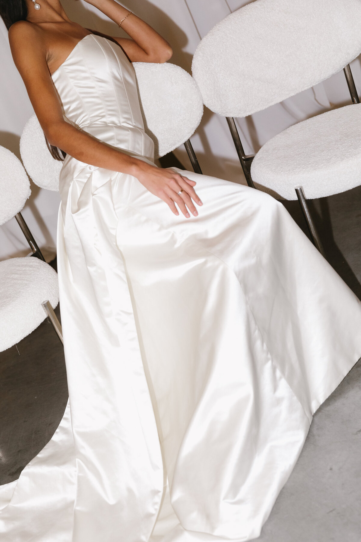 Editorial detail of a long satin bridal train in an elegant wedding setting.