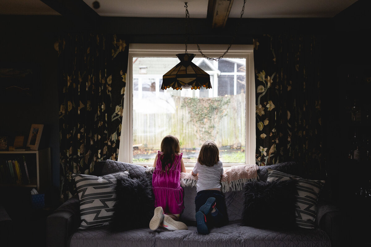 Two young children looking out the window