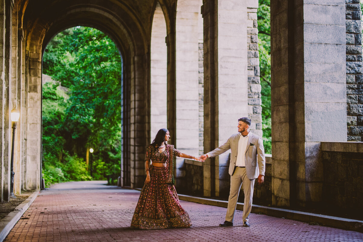A couple in indian clothing in the billings tunnel at fort tryon park in nyc during their engagement session