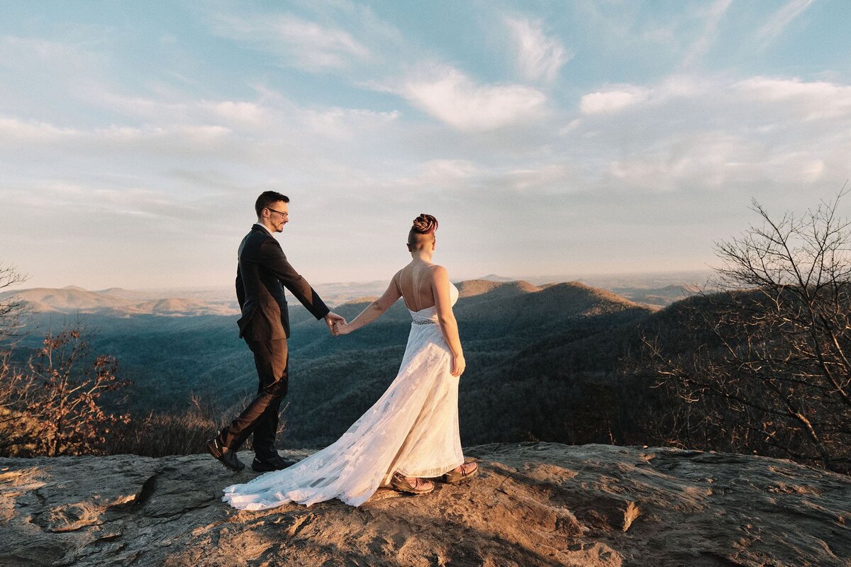 Eloping couple walking on top of a mountain