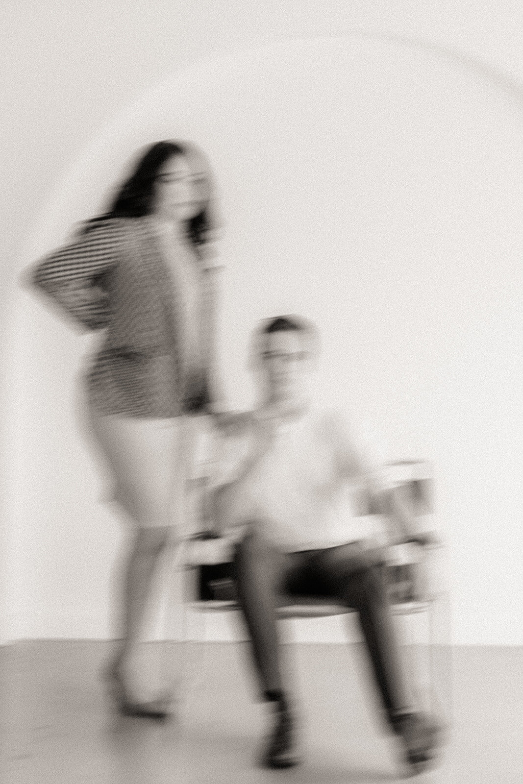 A blurred shot of two people posing with a chair