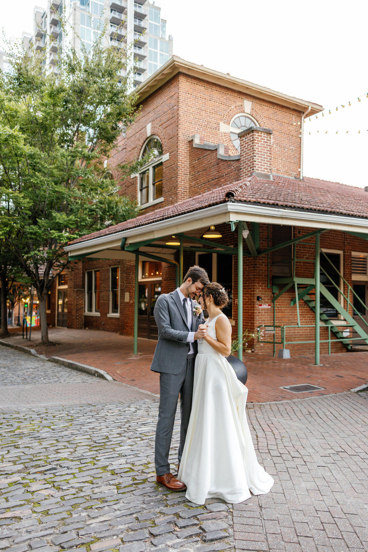Newlywed couple sharing an intimate moment on a Raleigh street, urban wedding photography