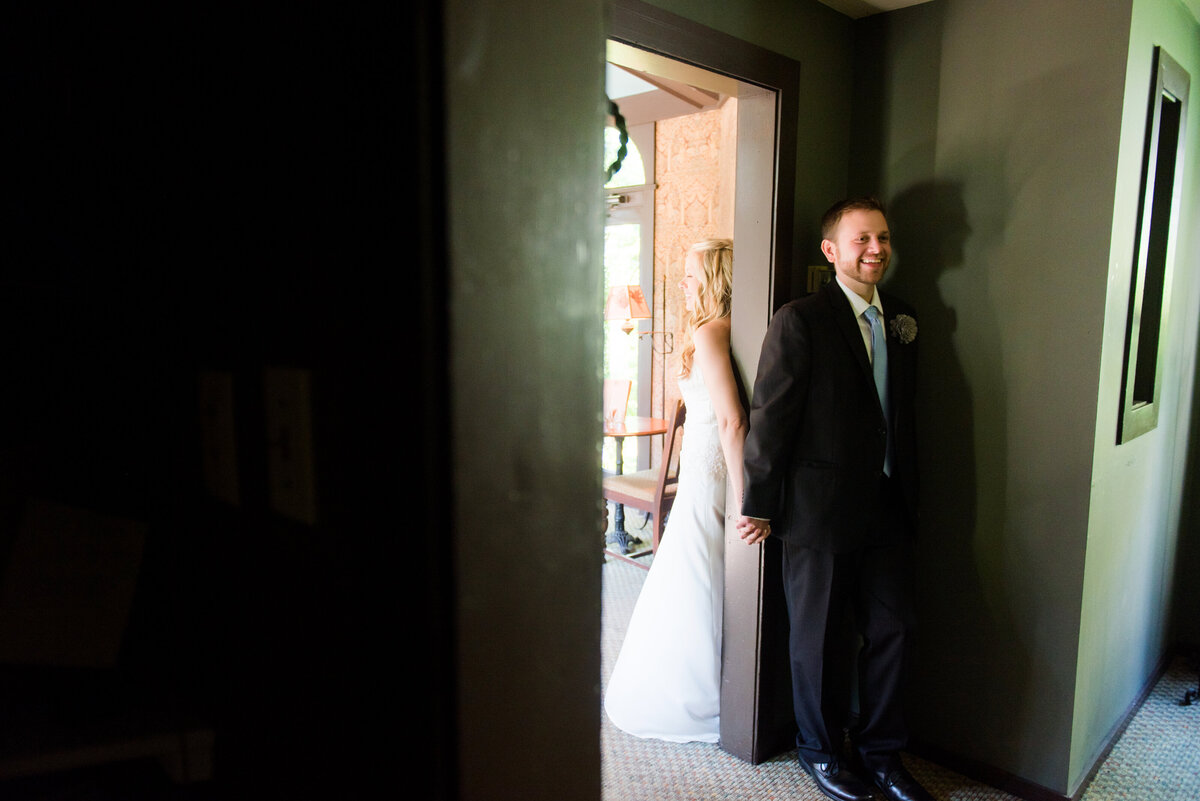 couple holding hands around a wall at the Hyeholde on their wedding day before their ceremony