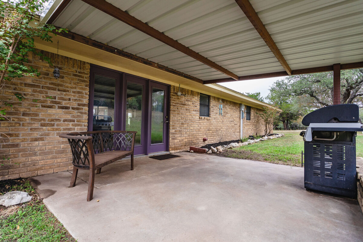 Covered porch area with outdoor seating and grill at this three-bedroom, two-bathroom ranch house for 7 with incredible hiking, wildlife and views.