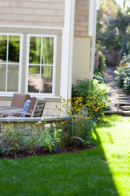 A well-manicured landscape surrounding a modern home with large windows.