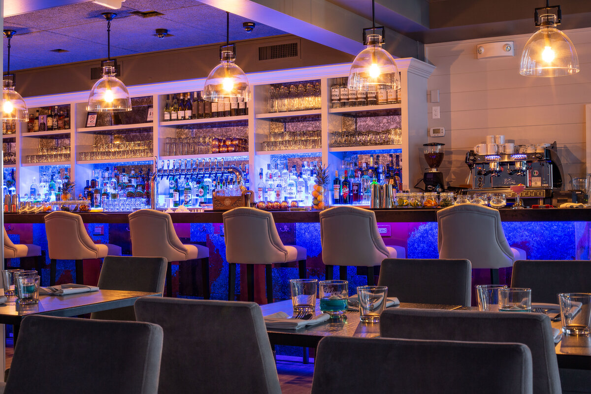 dimly lit modern bar with blue uplighting