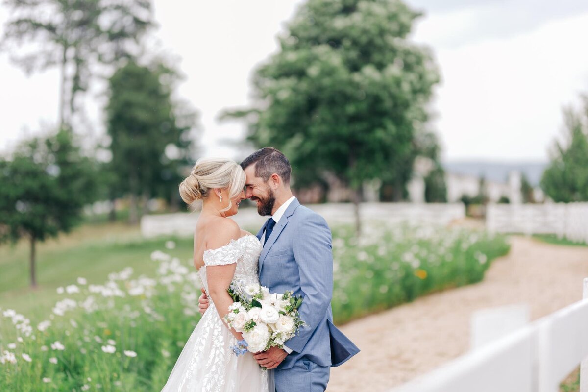 A bride and groom share an intimate moment amidst a blossoming garden.