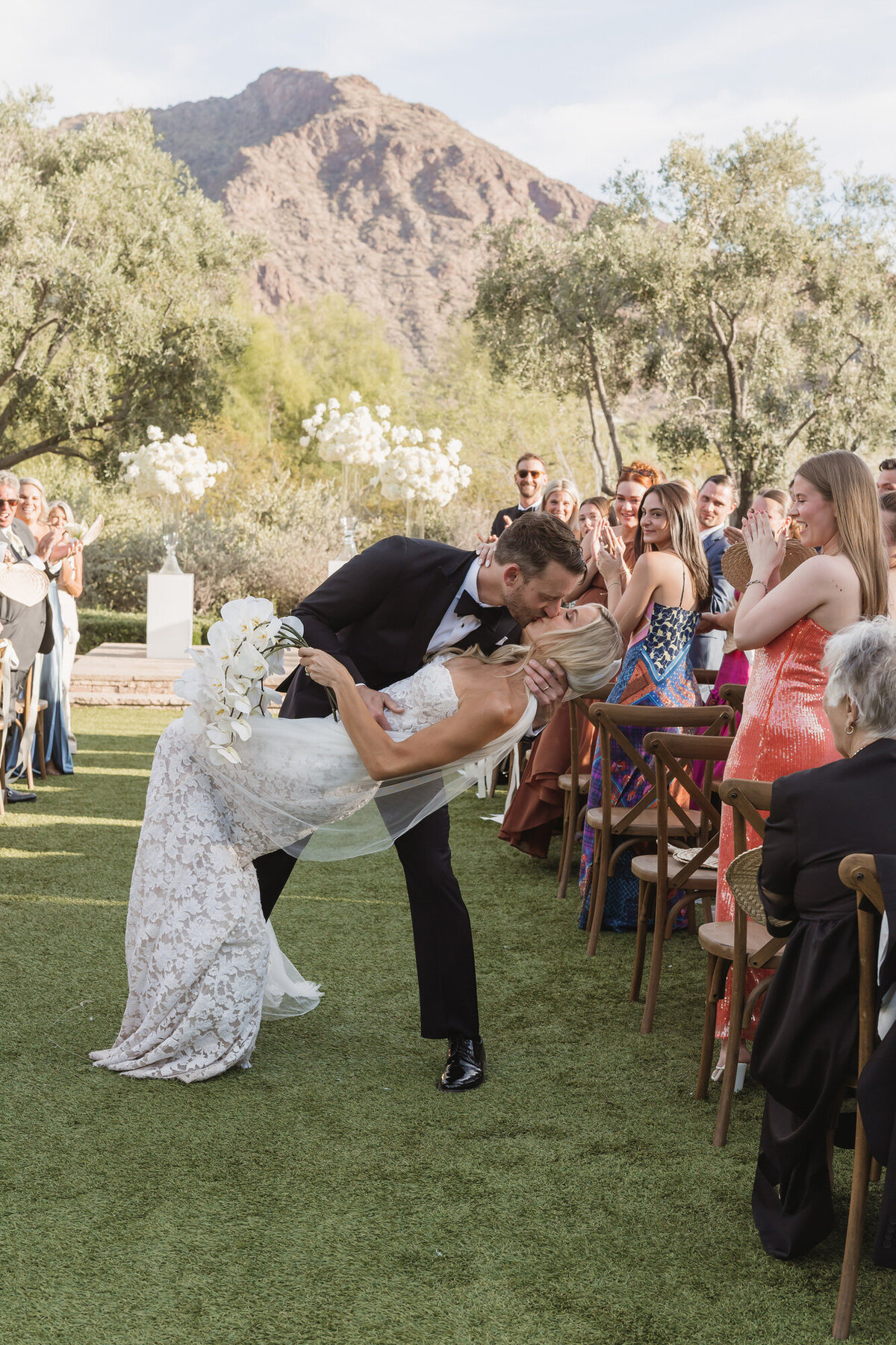 Groom dipping bride for a kiss at end of aisle leaving wedding ceremony at El Chorro