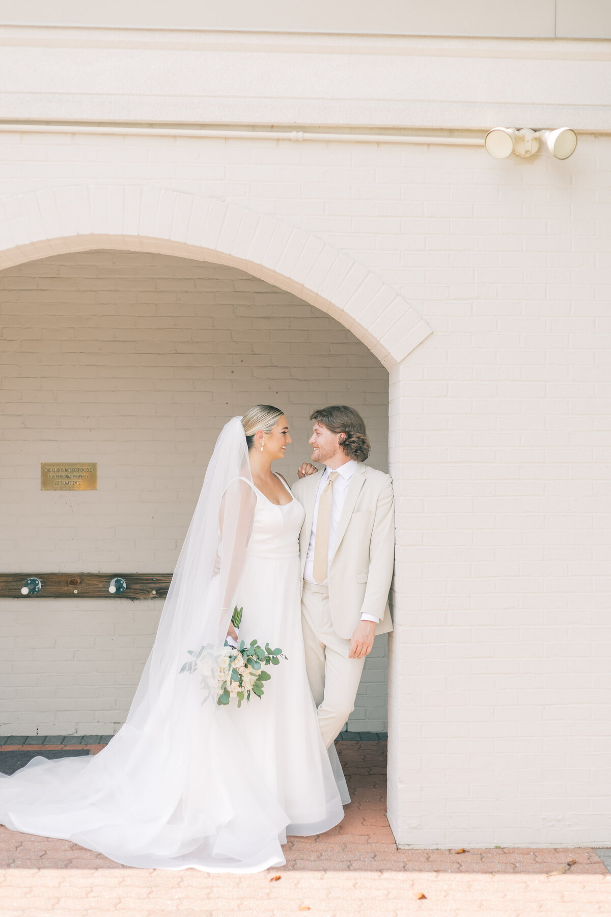 Couple under arch at Maryland golf course wedding.