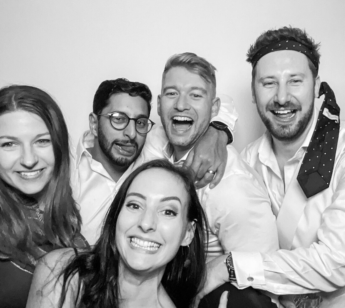 bride and guests posing against a white backdrop for a b&w kardashian style selfie pod rental in cotswolds, at hyde house