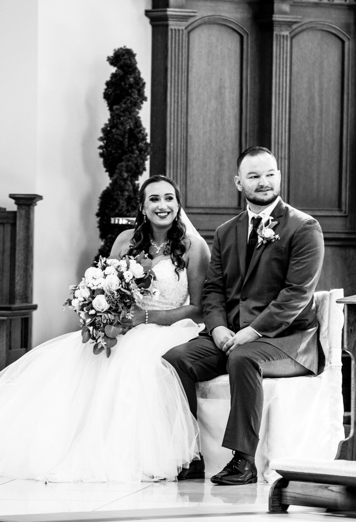 Bride-and-groom-ceremony-seated-in-church-black-and-white-portrait