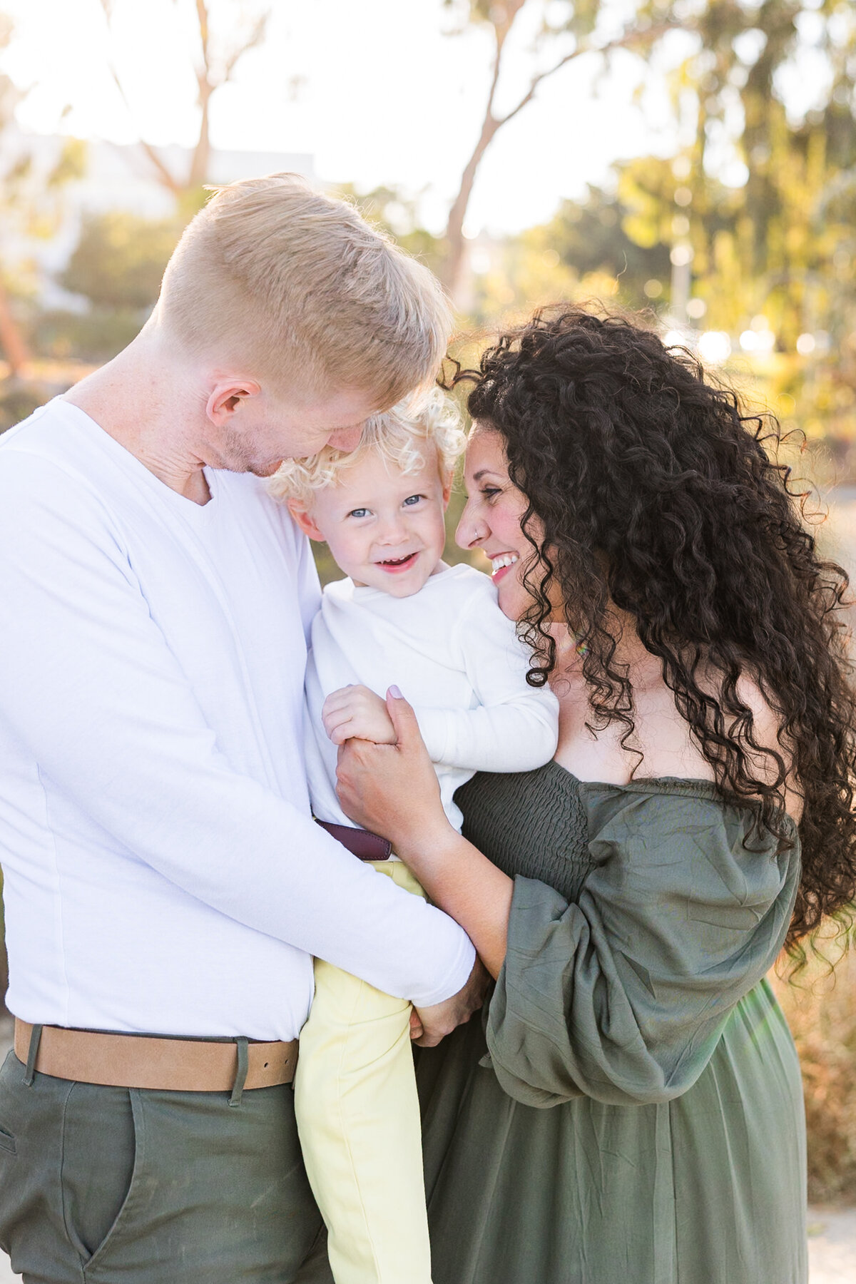 parents holding young son and smiling