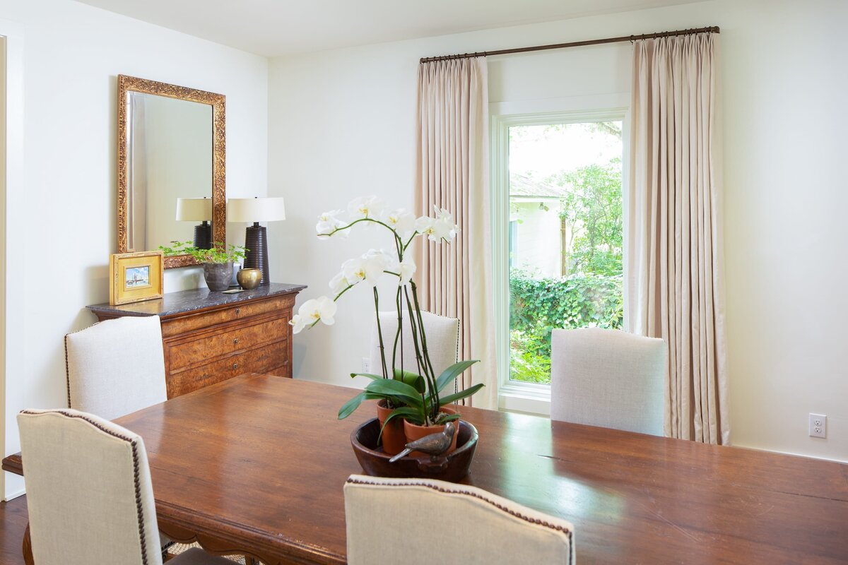 the keeping room interiors grant dining room wood table with whtie orchid in center