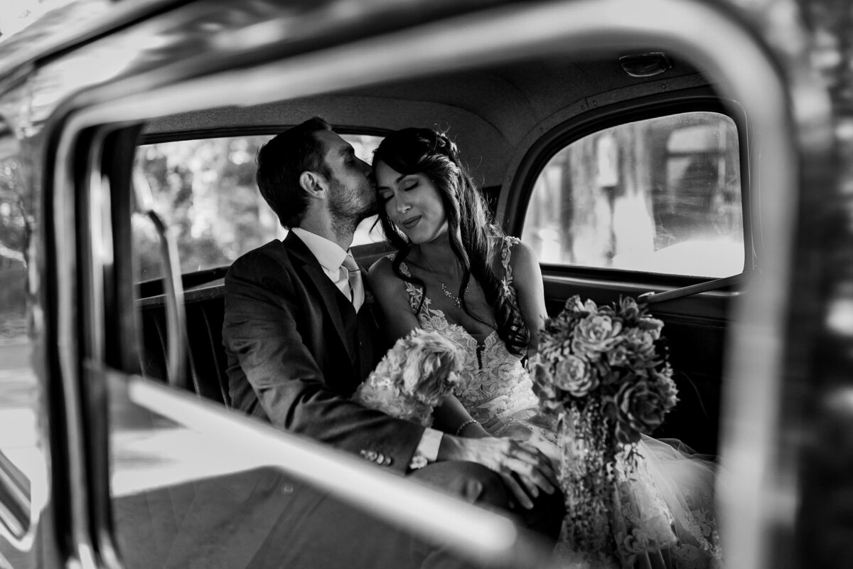 groom kissing bride in the car