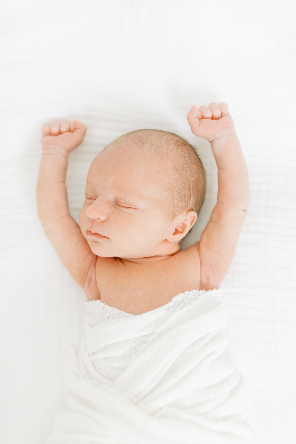 photo of newborn baby with his arms lifted by spokane newborn photographer