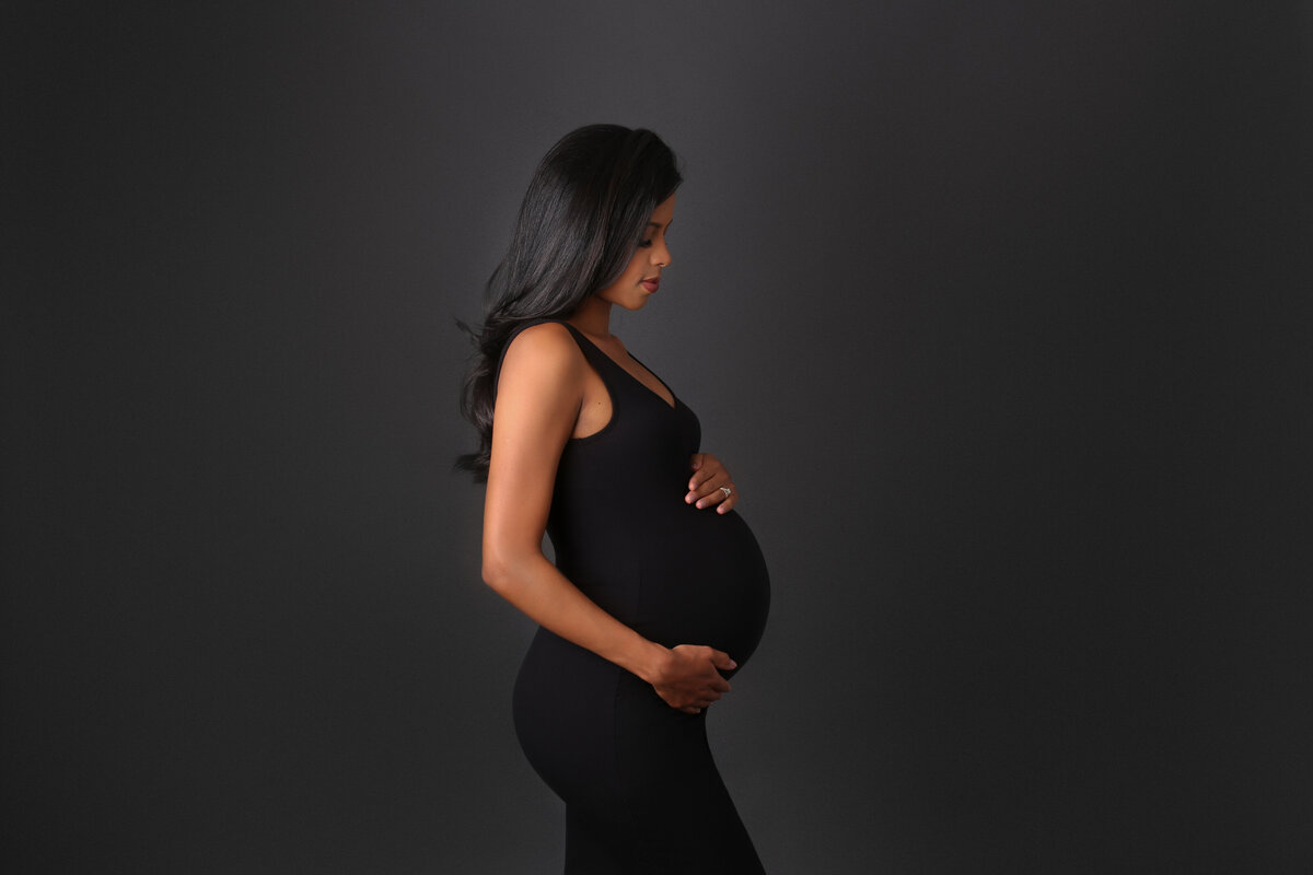 Photo of a pregnant woman dressed in a fitting black dress