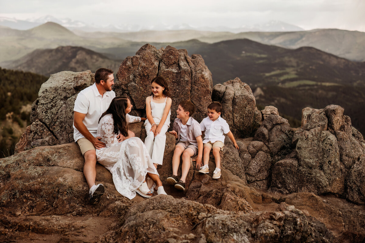 family of five share a quiet moment together on a mountain side in the forest of Colorado for their family pictures