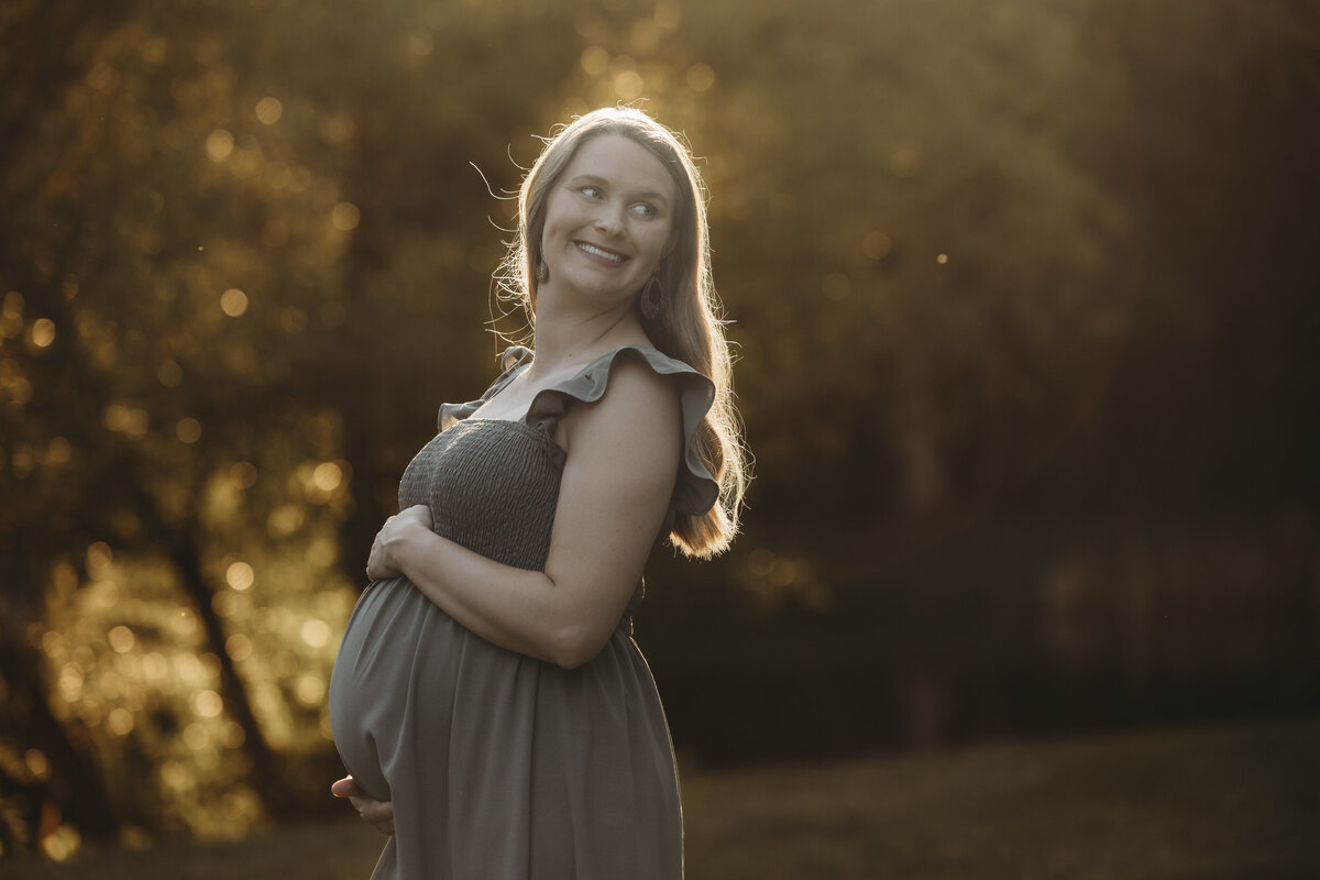 Expectant mother looking over her shoulder into the distance.