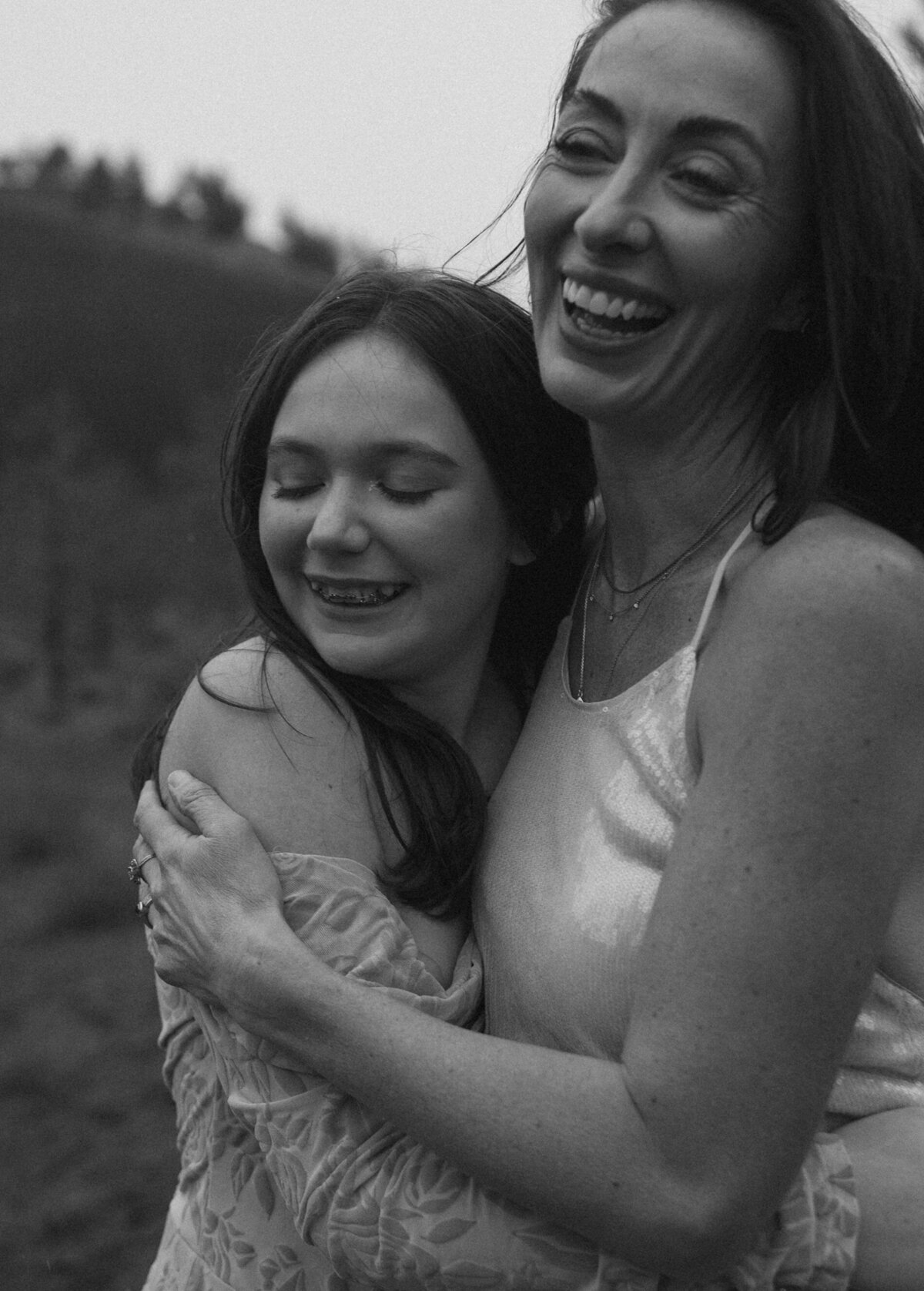 mother and daughter laughing together during a candid photoshoot in Bend, Oregon, surrounded by nature