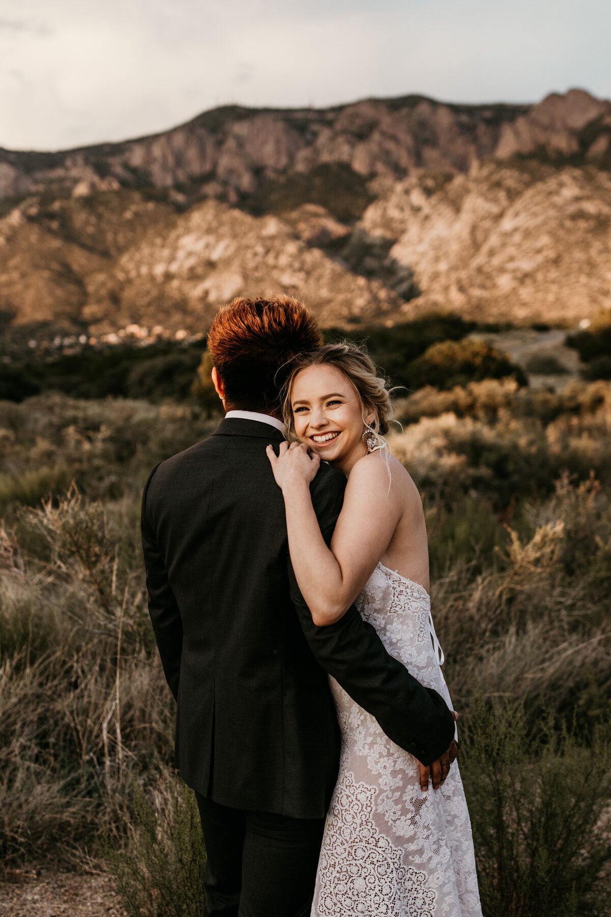 bride laughing over grooms shoulder