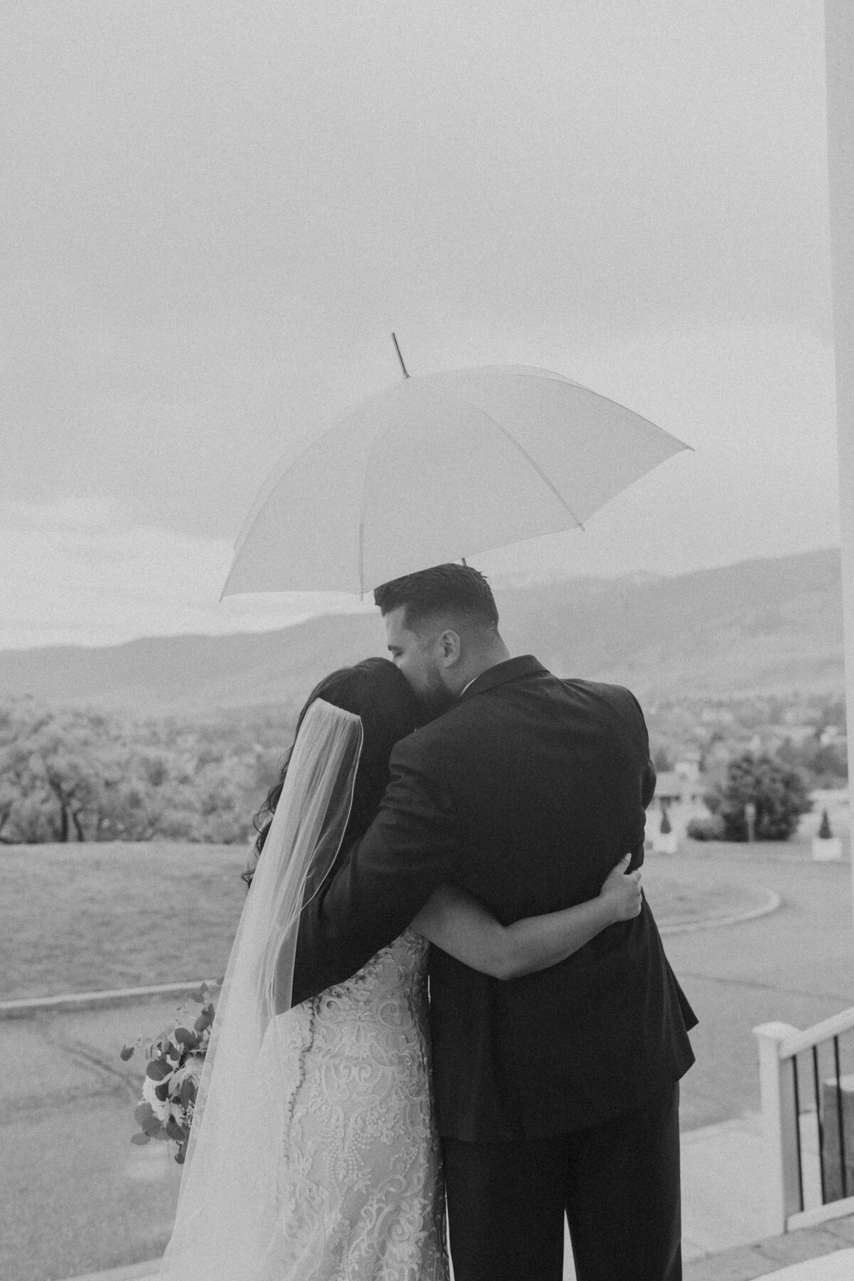 black and white photo of bride and groom in the rain