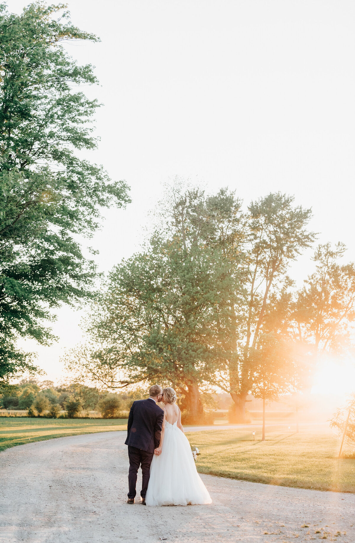 Bride and groom kissing during sunset wedding portraits at Willow Creek Barn by Nova Markina Photography