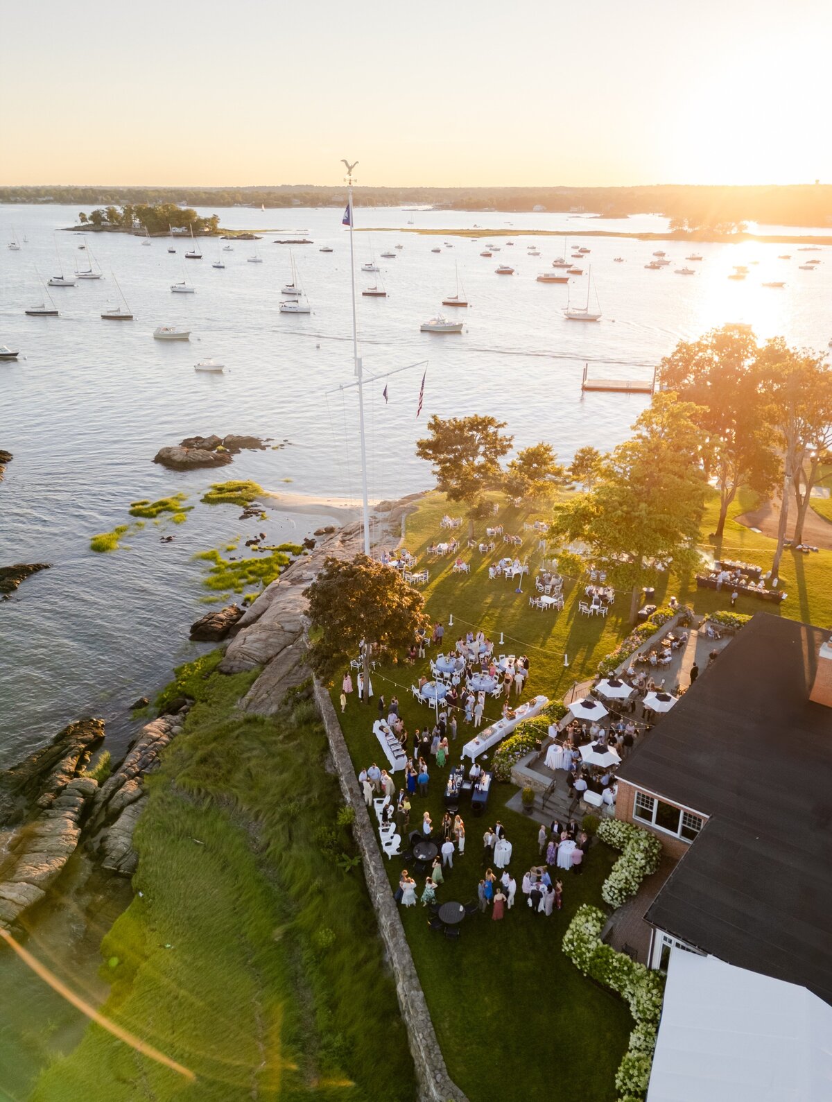aerial view of rehearsal dinner and welcome drinks at sunset on the lawn of American Yacht Club in Rye, NY 